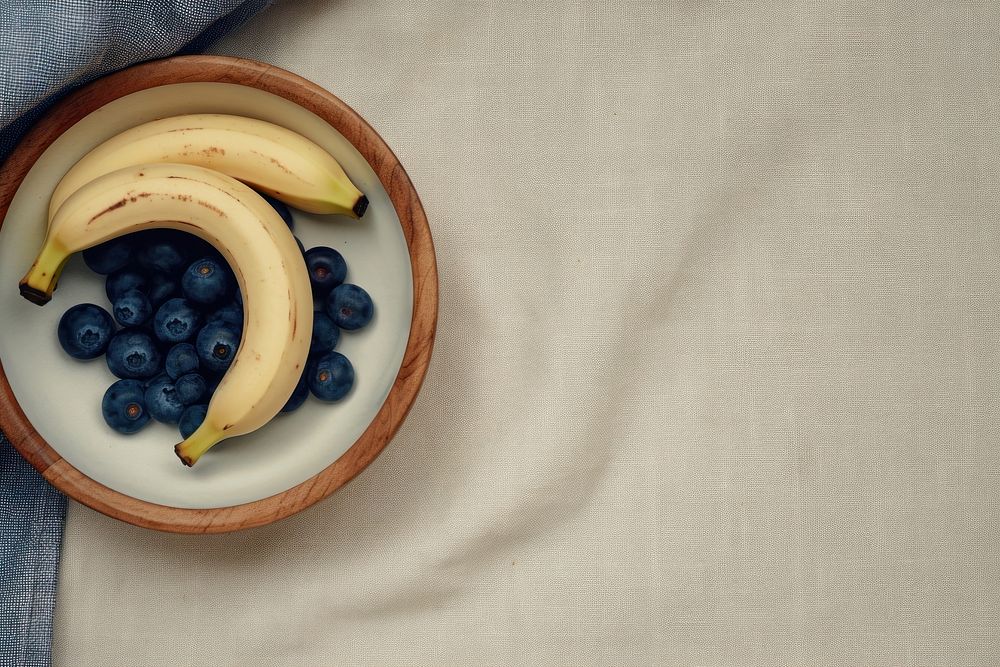 Oatmeal bowl with blue berries and banana sliceds blueberry fruit plant.