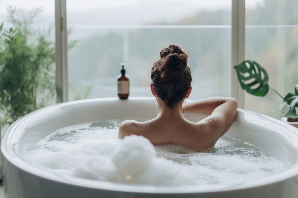 Photo of person in large tub bathtub jacuzzi adult.