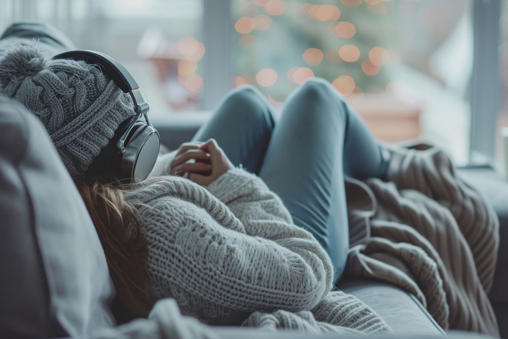 Photo of person listening music on sofa blanket comfortable electronics.