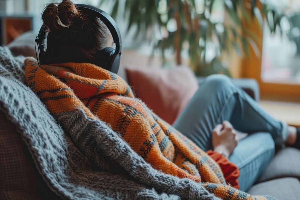 Photo of person listening music on sofa blanket adult comfortable.