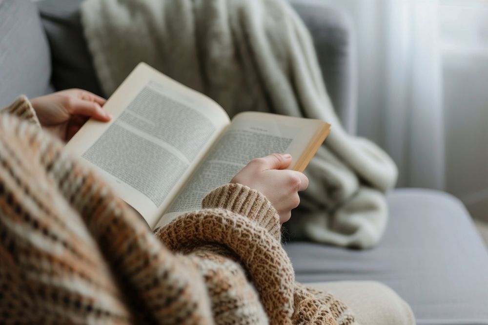 Photo of person reading book on sofa publication adult comfortable.