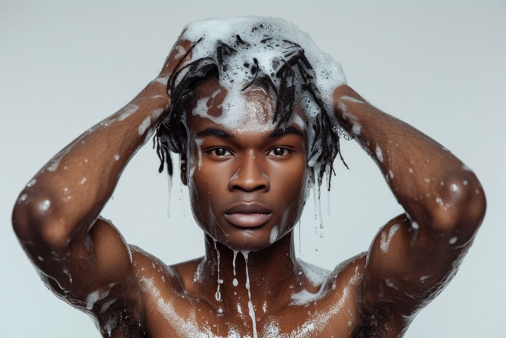 Black man washing hair with shampoo caesar short hair portrait bathing head.