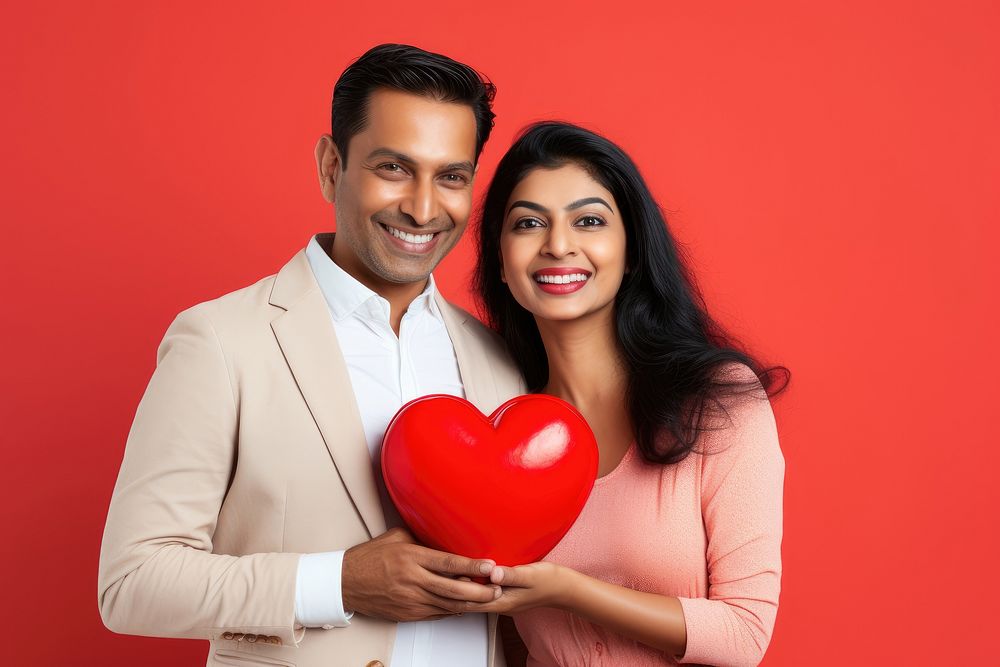 Indian couple holding a heart balloon adult love.