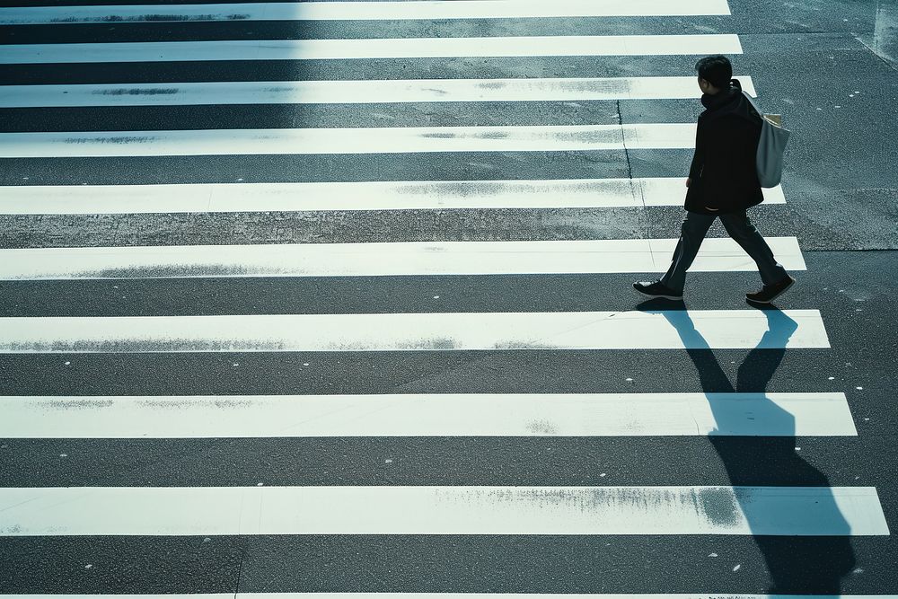 Person walking pedestrian crossing asphalt.