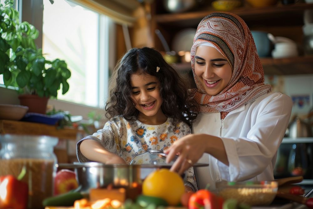 Middle eastern mom and daughter cooking together smiling family child.