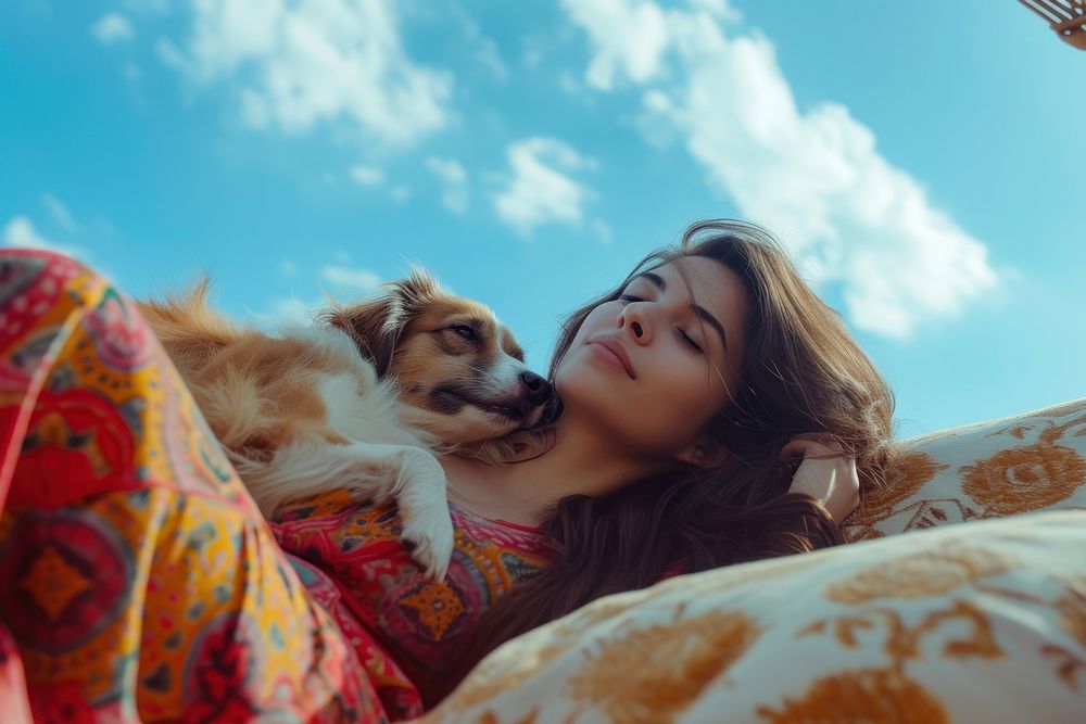 Middle Eastern woman playing with dog on sofa blanket adult sky.