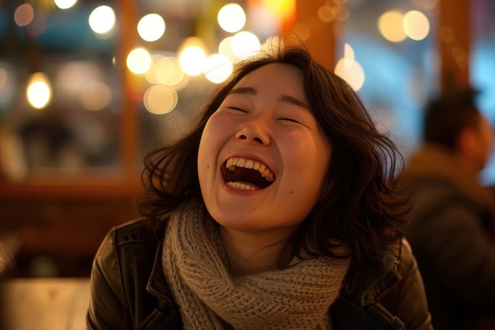 Korean woman laughing adult eyes closed.