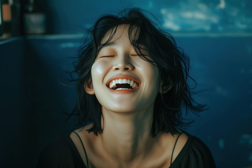 Korean woman laughing smile eyes closed.
