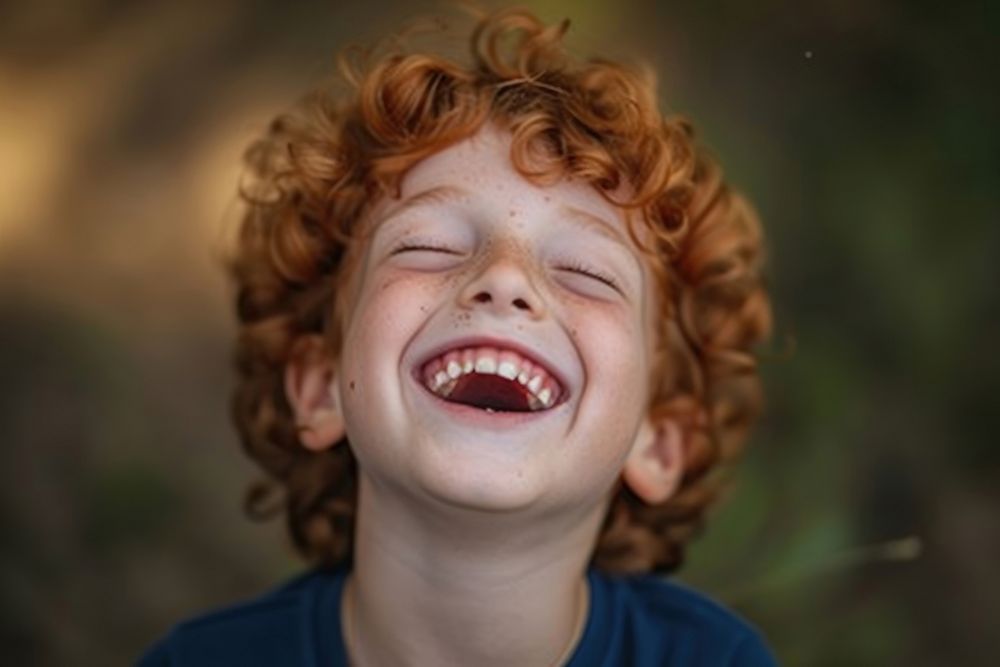 Young british boy laughing baby eyes closed.