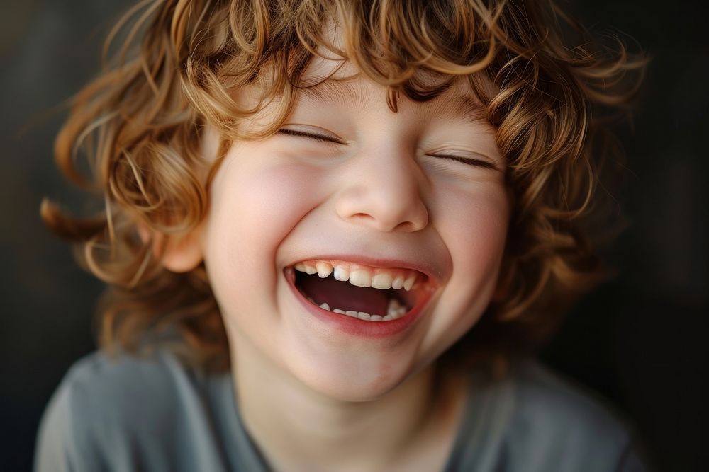 Young british boy laughing baby eyes closed.