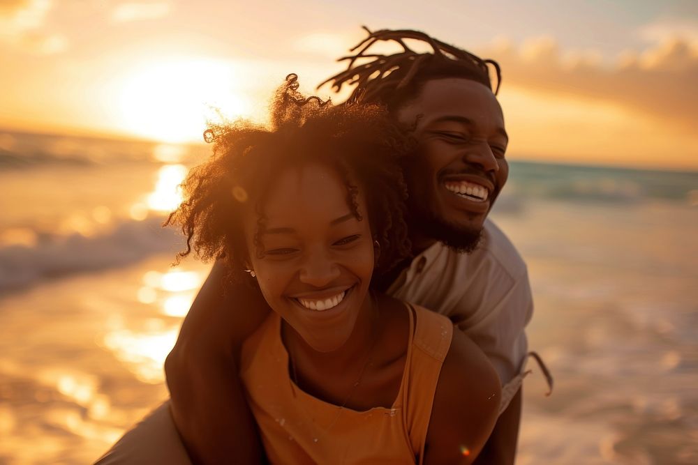 Black couple laughing outdoors sunset.