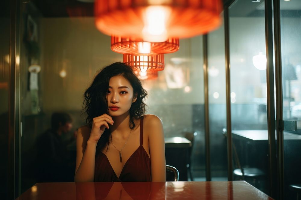 Asian woman eating in a restaurant portrait light table.