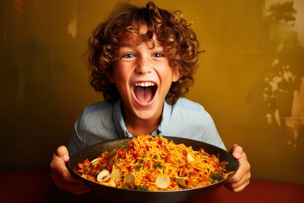 Young boy eating paella food restaurant happiness.
