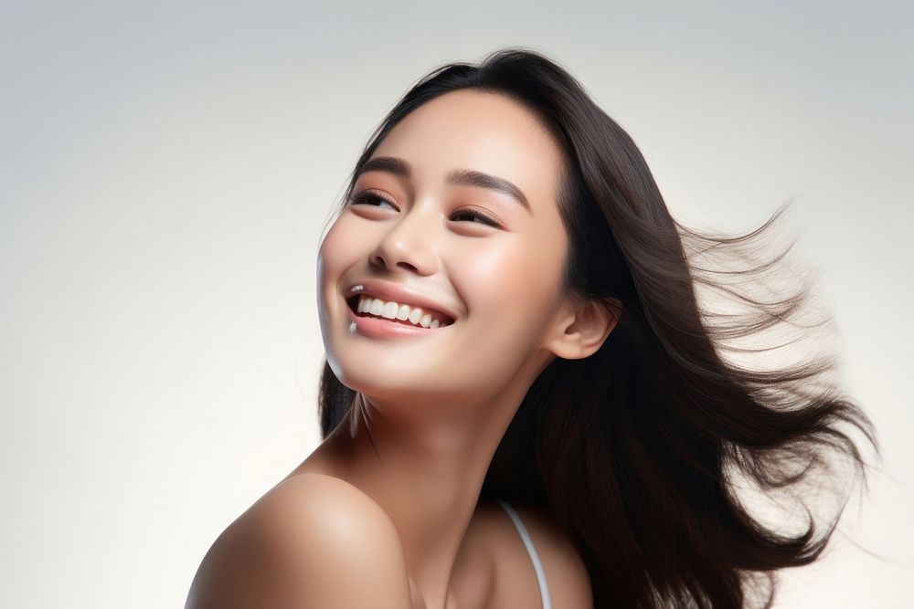 A young Filipino woman with cosmetic product laughing adult smile.