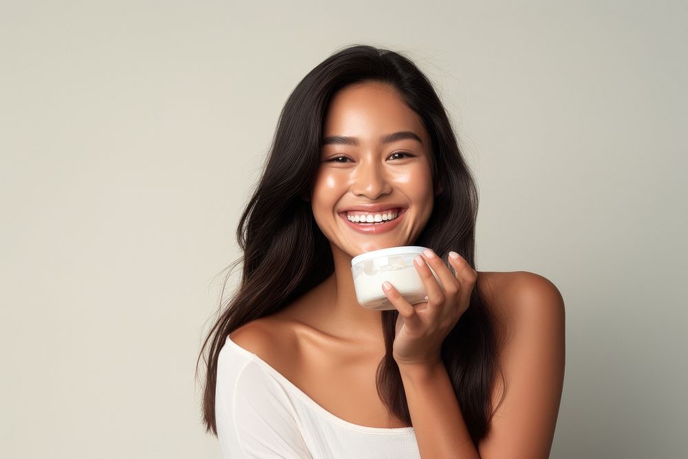 A young Filipino woman with cosmetic product laughing smile happy.