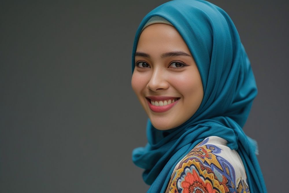 Young Muslim woman speaker on professional stage smiling scarf smile.