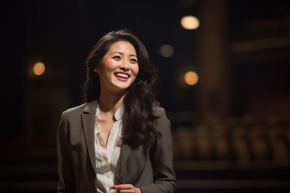 Asian woman speaker on professional stage smiling smile night.