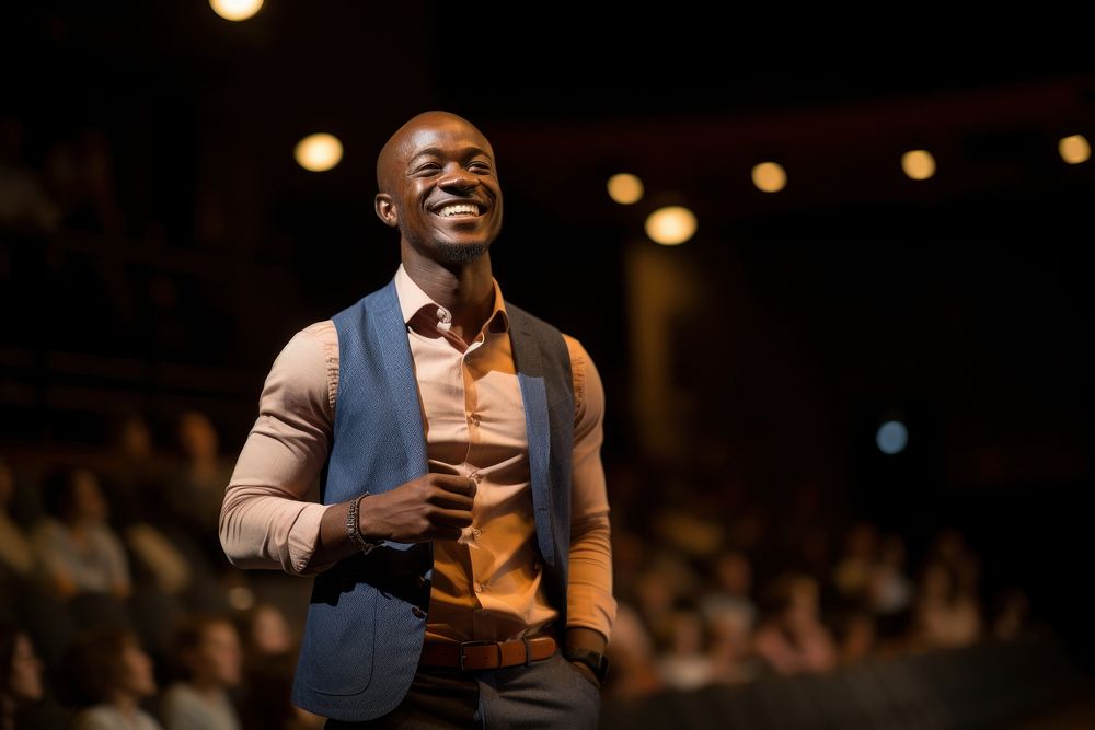 Black man speaker on professional stage audience smiling adult.