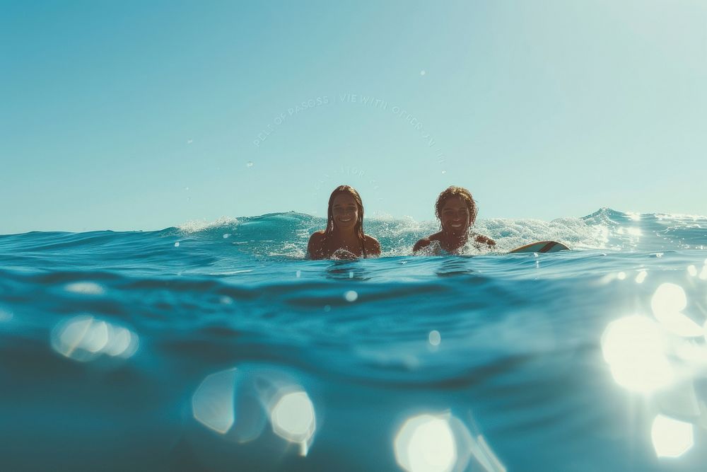 Woman and friend Surfers swimming ocean outdoors.