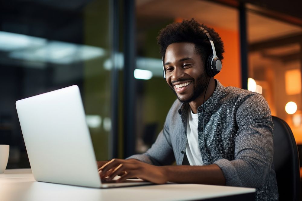 Black man working at call center laptop headphones computer.