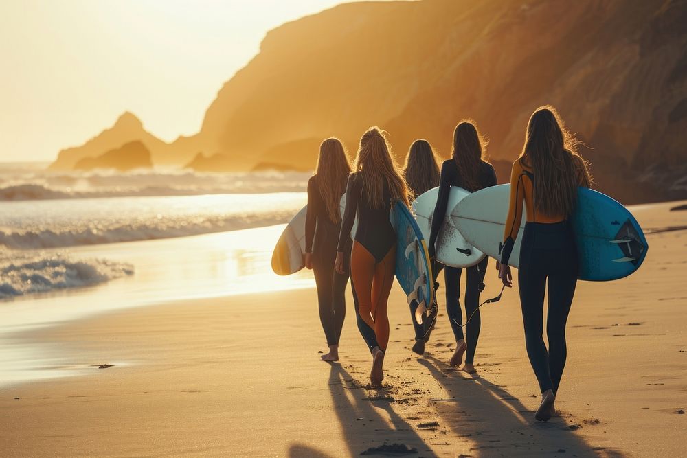 Group of female surfers walking on the beach outdoors vacation surfing.