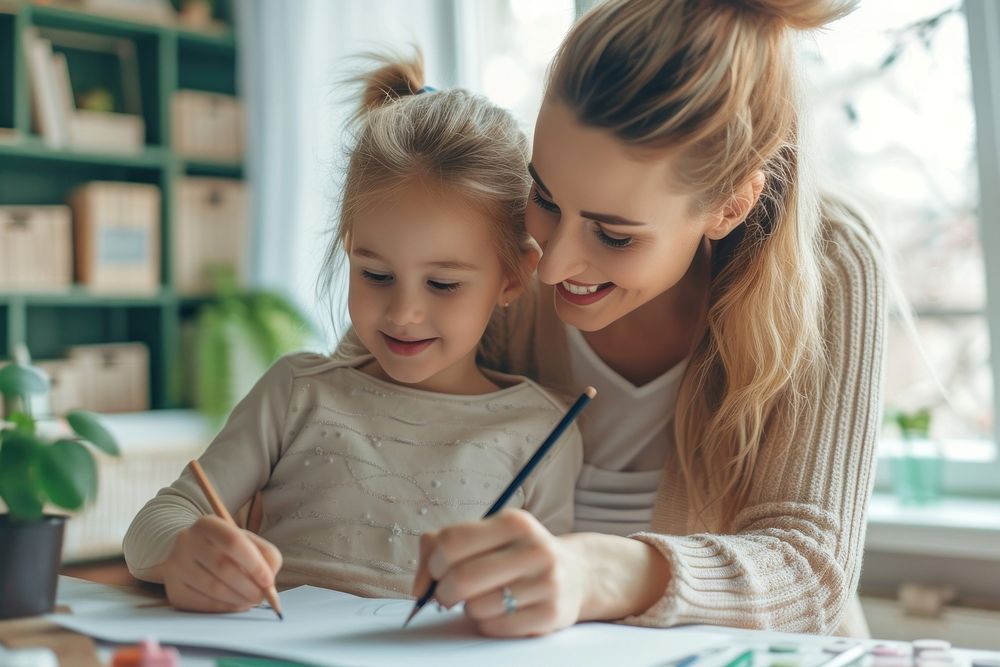 Happy mother and daughter drawing at home writing child pen.