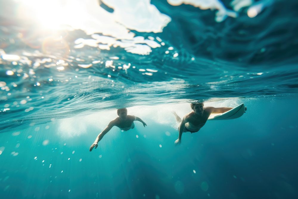 Man and friend Surfers swimming ocean underwater.