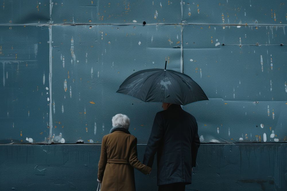 Senior man holding unbrella over woman adult coat rain.