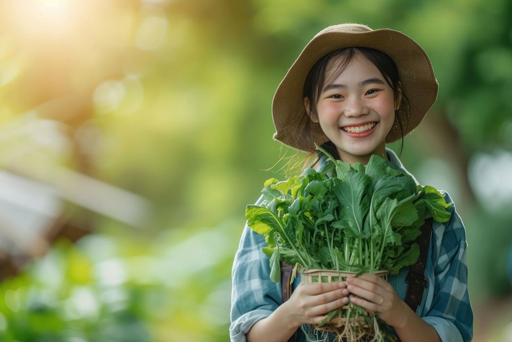 A happy japanese girl farmer holding vegetables organic smile plant.