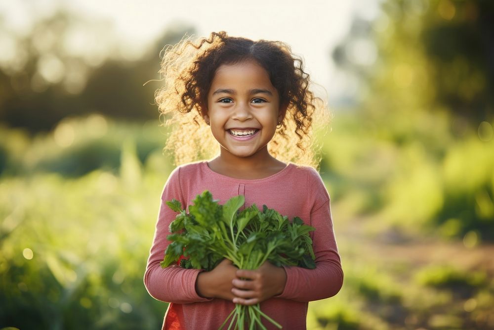 A happy Latino girl farmer holding vegetables smile organic child.