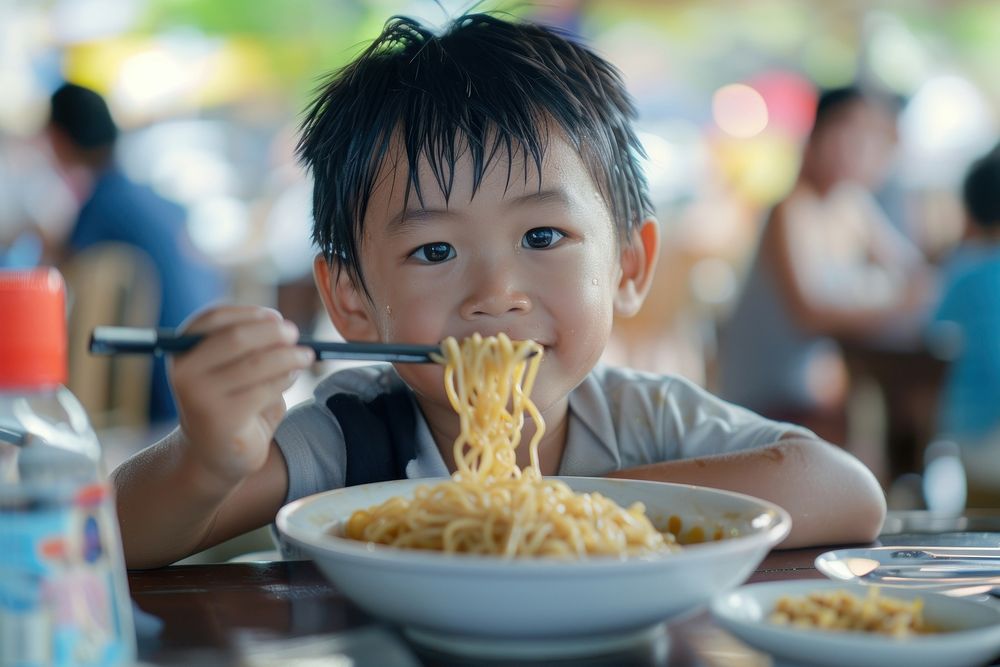 Suth east asia boy eat noodle restaurant eating food.