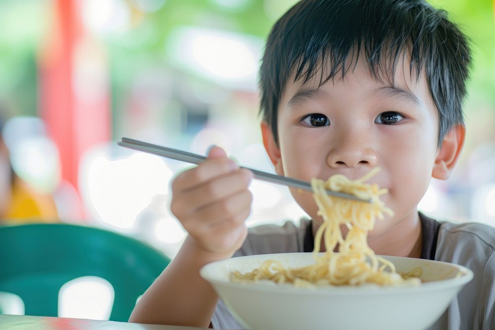 Thai boy eat noodle chopsticks eating food.