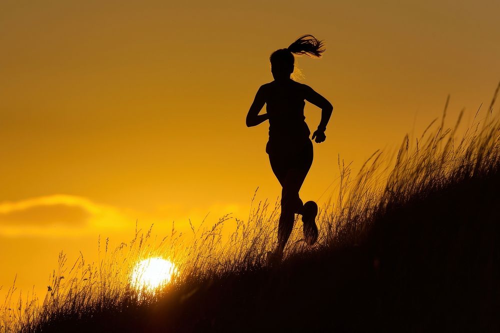 Woman running up hillside backlighting silhouette adult.