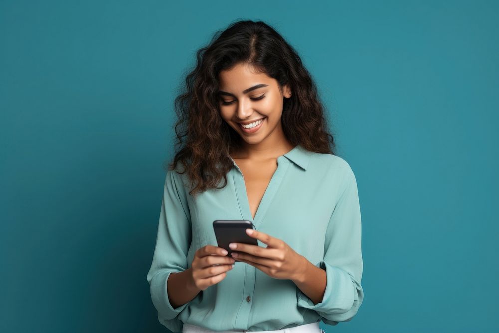 Latin woman holding mobile phone smiling happy blue.