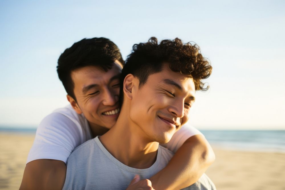 Korean gay couple portrait beach laughing.