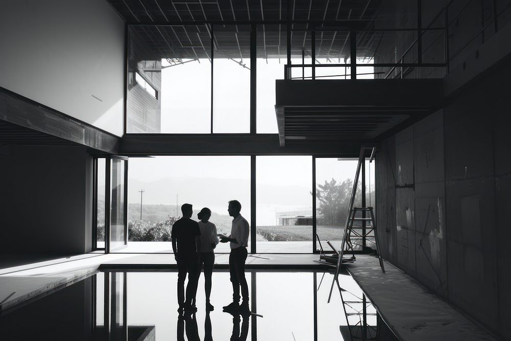 Four architects inspecting an under construction home architecture togetherness monochrome.
