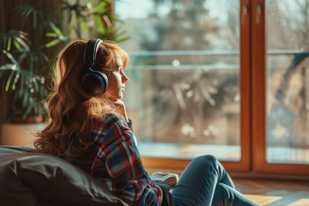 Photo of Woman listening to music at home headphones sitting adult.