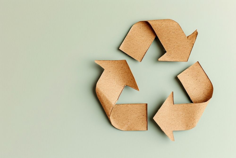 Brown Paper cut into the shape of a recycling symbol paper circle yellow.