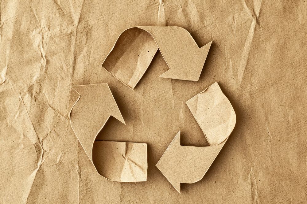 Brown Paper cut into the shape of a recycling symbol paper brown crumpled.