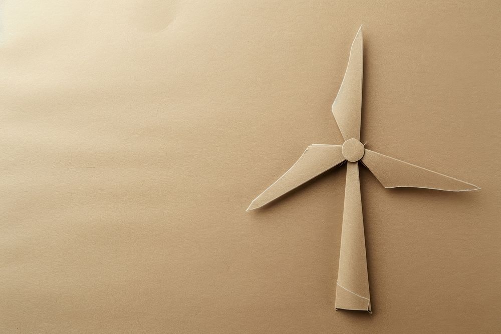 Brown paper punch into the shape of a wind turbines electricity copy space propeller.