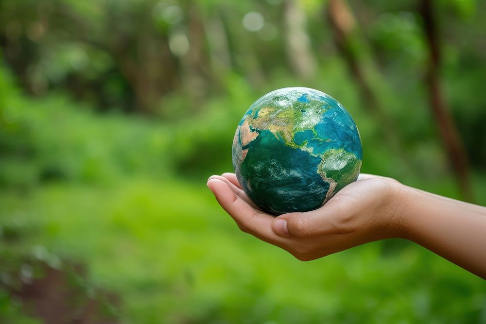 Hand holding green planet Earth sphere space globe.