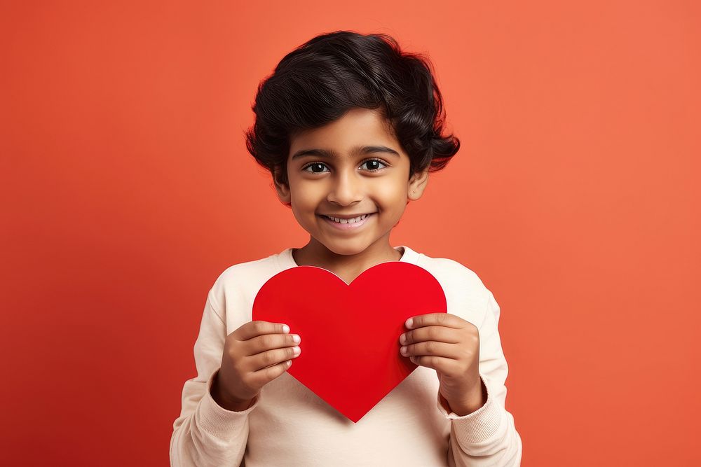 Indian kid holding a paper heart love happiness innocence.