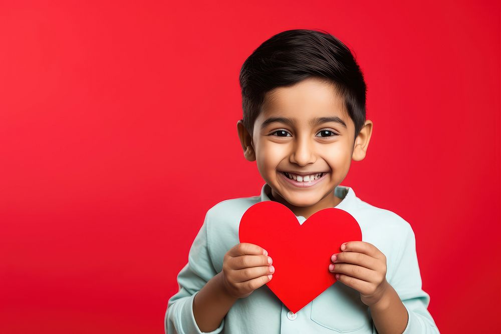 Indian kid holding a paper heart child love happiness.