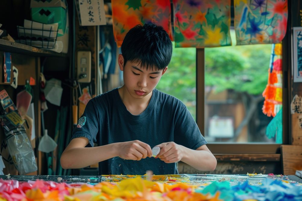 Japanese boy using stationary concentration craftsperson entrepreneur.