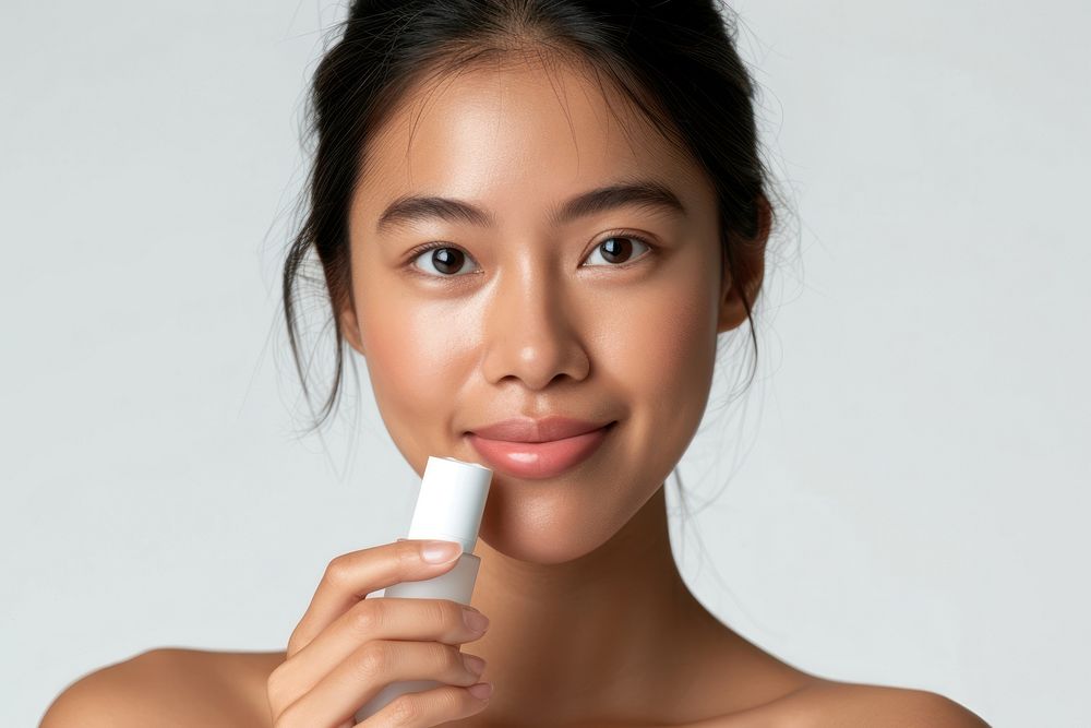 Middle age woman holding a skincare bottle cosmetics portrait toothbrush.