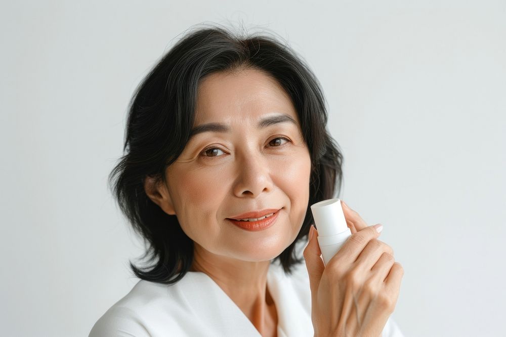 Middle age woman holding a skincare bottle cosmetics portrait adult.