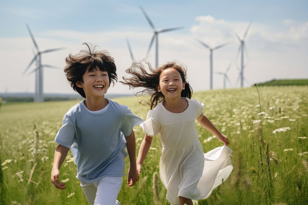 Girl and boy are running in field windmill outdoors nature.