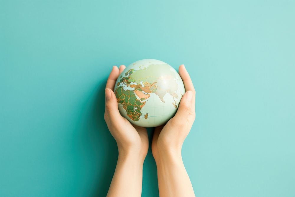 Hand holding a Handmade green Globe globe planet topography.