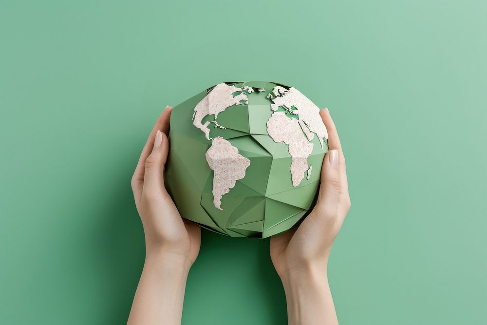 2 hands holding a paper craft earth sphere planet globe.