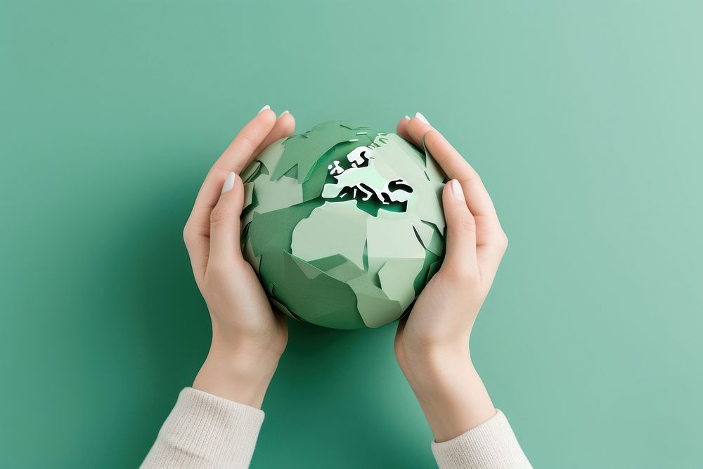 2 hands holding a paper craft earth sphere green environmentalist.